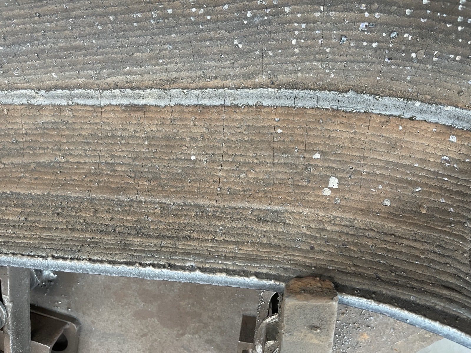 Close-up of chromium carbide overlay surface showing weld beads and the typical stress-relief crack pattern