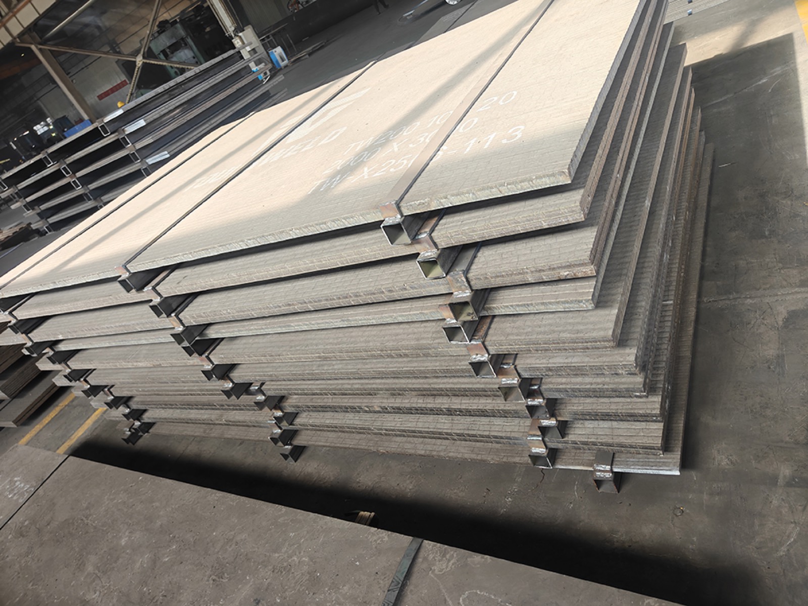 Stack of finished TW200 plates separated by welded spacers in the workshop